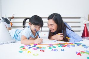 Mother and daughter studying the alphabet together, a bonding activity to enhance early literacy skills